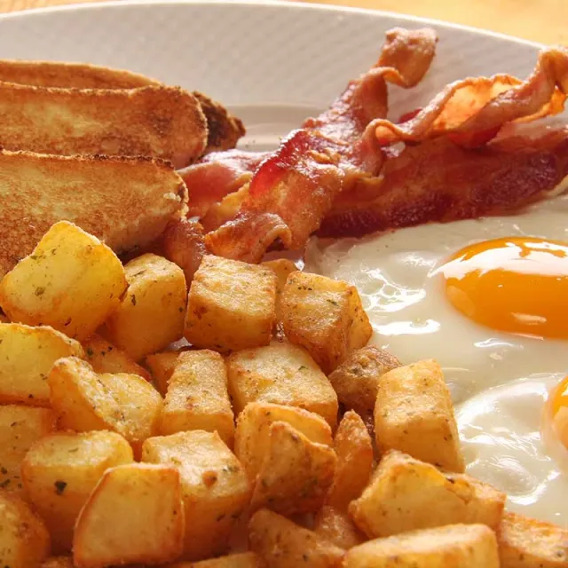 A plate featuring eggs, crispy bacon, and golden-brown roasted potatoes.