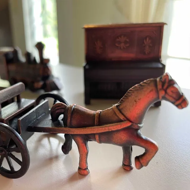 A small horse figurine pulling a carriage on a table.