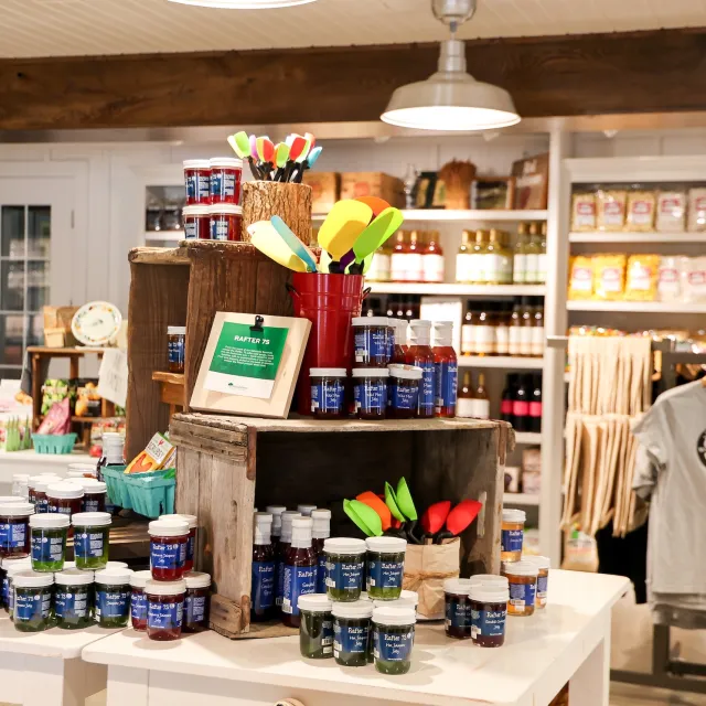 A vibrant display of colorful jars and silicone spatulas in a cozy shop, showcasing artisanal products and local goods.