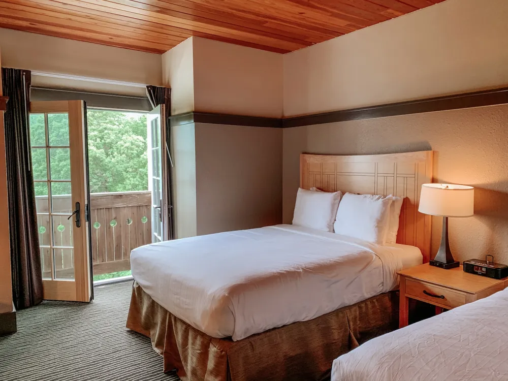 A room featuring two beds and a sliding door, creating a spacious and inviting atmosphere.