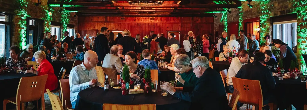 Gathering of people at tables in a banquet room with festive lights and atmosphere