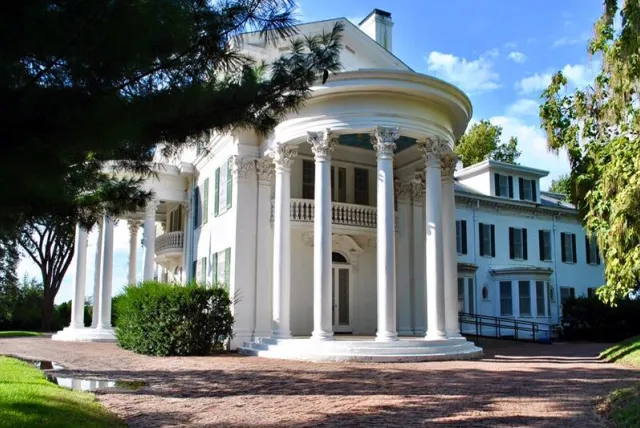 Arbor Lodge Mansion featuring tall columns and a spacious porch, showcasing classic architectural design.