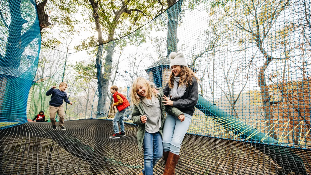 A group of children joyfully playing together on a net.