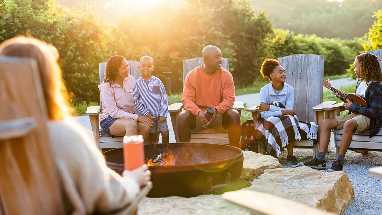 Family sitting around Lied Lodge Campfire
