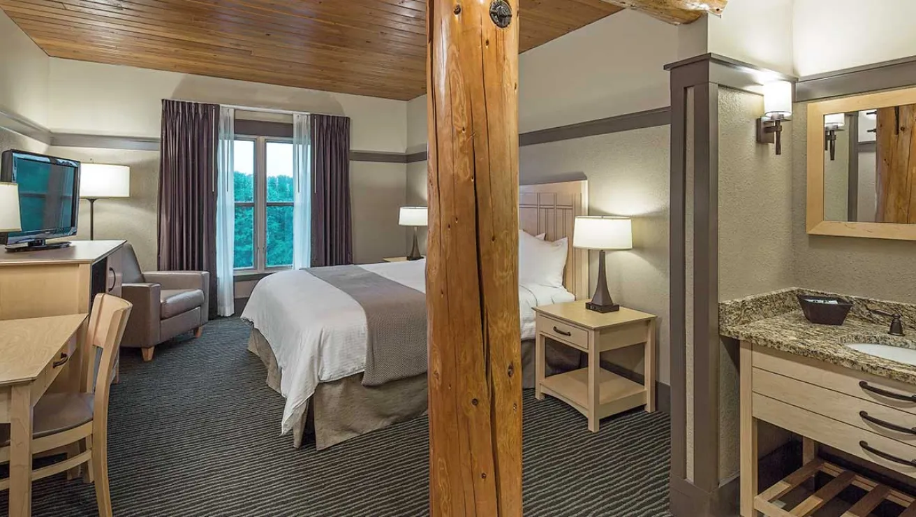 A hotel room featuring a bed, a desk, and a television, creating a comfortable and functional space for guests.