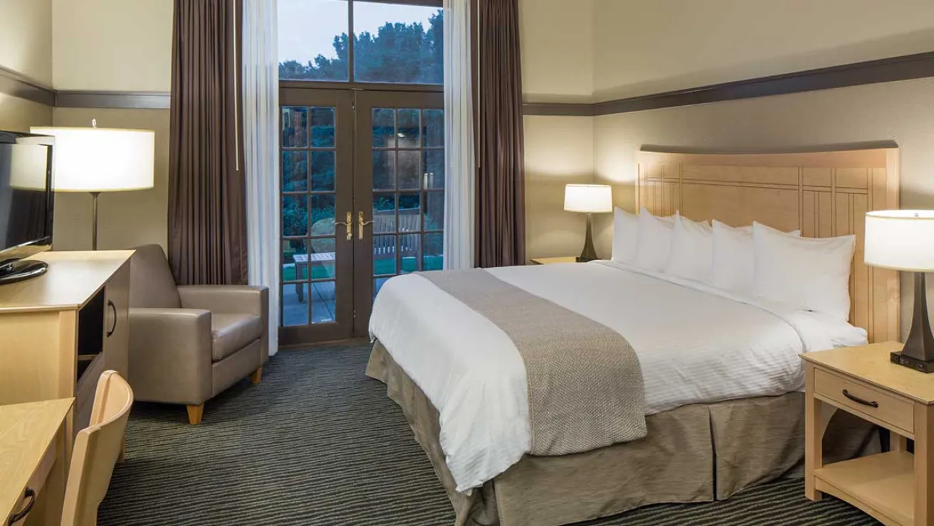 A hotel room featuring a bed, a desk, and a television, creating a comfortable and functional space for guests.