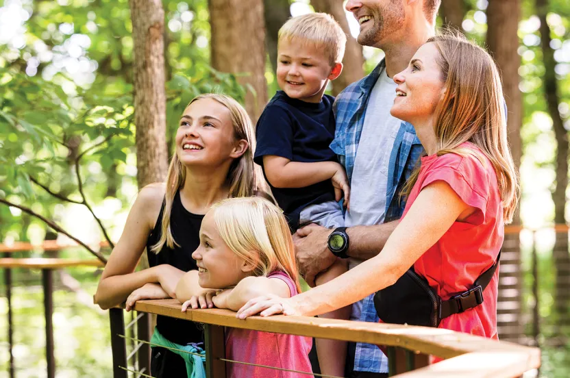 Family looking up at trees on walkway