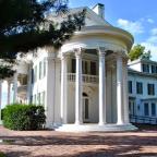 Arbor Lodge Mansion featuring tall columns and a spacious porch, showcasing classic architectural design.