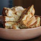 A stack of french toast within a light coral bowl.